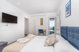 ein Schlafzimmer mit einem großen Bett und einem TV an der Wand in der Unterkunft Apartman Spin in Kastav
