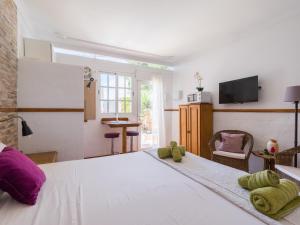 1 dormitorio con 1 cama grande con almohadas moradas y verdes en Casa Las Tuneras, Solo Adultos, en La Oliva