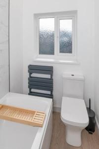 a bathroom with a white toilet and a window at Charming Gateshead Retreat - Close to Newcastle - Angel of the North in Sheriff Hill