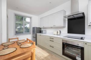 a kitchen with a wooden table and a stove at Charming Gateshead Retreat - Close to Newcastle - Angel of the North in Sheriff Hill