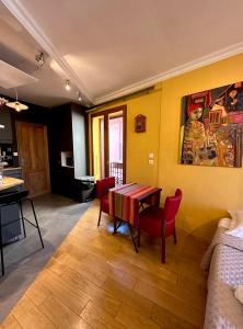 a dining room with a table and red chairs at Lumières à Collioure in Collioure