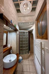 La salle de bains est pourvue d'un grand lavabo blanc et d'un lustre. dans l'établissement Lumières à Collioure, à Collioure