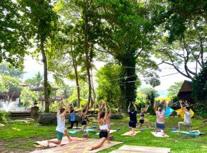 a group of people doing yoga in the park at Shaya Suandoi Resort in Pai