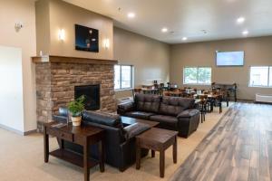 a living room with leather furniture and a fireplace at Cobblestone Hotel & Suites-Sheldon in Sheldon