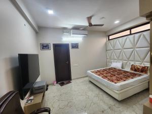 um quarto com uma cama e uma televisão de ecrã plano em EL Dorado 11 em Indore