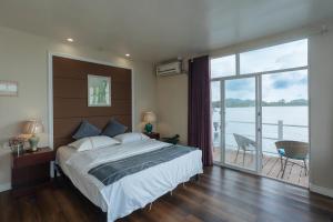 a bedroom with a large bed and a large window at Seaward 270 degrees deluxe ocean view room with queen bed in Koror