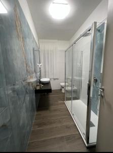 un bagno con doccia, WC e lavandino di Allen apartments a Siracusa