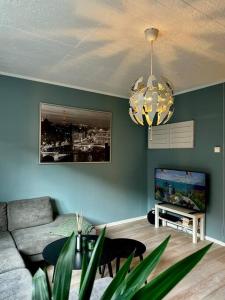 a living room with a couch and a chandelier at Great apartment centrally located on Majorstua in Oslo