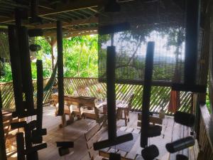 a screened in porch with a hammock and benches at Kakuna Lodge in Minca