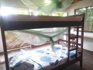 a bunk bed with a canopy in a room at Kakuna Lodge in Minca