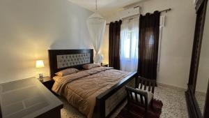 1 dormitorio con cama, mesa y ventana en The vintage apartment en Amán