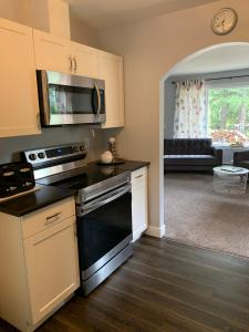 a kitchen with a stove top oven next to a living room at Stoneshire Guesthouse in Clearwater