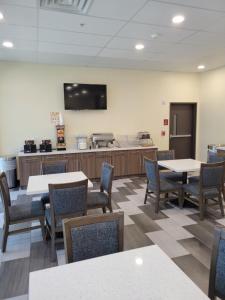 a waiting room with tables and chairs and a flat screen tv at Comfort Inn Miramar Beach - Destin in Destin