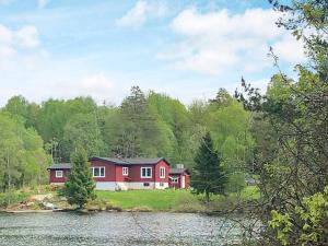 ein rotes Haus am Ufer eines Sees in der Unterkunft Holiday home NÖDINGE 