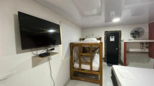 ein Wohnzimmer mit einem Flachbild-TV an der Wand in der Unterkunft WAYANAY TAYRONA ECO HOSTEL in El Zaino