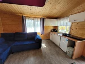 ein Wohnzimmer mit einem Sofa und einer Küche in der Unterkunft Domki letniskowe Swinoujscie in Świnoujście