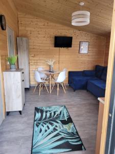 a living room with a blue couch and a table at Domki letniskowe Swinoujscie in Świnoujście