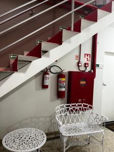 モジー・グァスーにあるApart Hotel Seg Total Lofts Encantadoresの椅子と消火器付きの階段