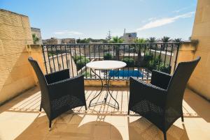 um pátio com uma mesa e cadeiras numa varanda em Dar ta' Censina Villa with Private Pool em Għasri