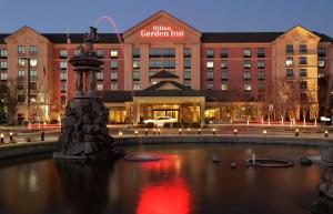 a hotel with a fountain in front of a building at Hilton Garden Inn Atlanta Airport/Millenium Center in Atlanta