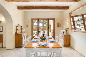 una cucina e una sala da pranzo con tavolo e sedie di Dar ta' Censina Villa with Private Pool a Għasri