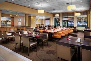 a dining room with tables and chairs in a restaurant at Hilton Garden Inn Atlanta Airport/Millenium Center in Atlanta