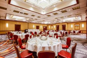 a banquet hall with white tables and red chairs at DoubleTree by Hilton Chicago/Alsip in Alsip