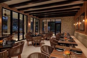 un restaurante con mesas, sillas y ventanas en Hoodoo Moab, Curio Collection by Hilton, en Moab