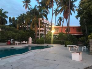 uma piscina com uma mesa e um edifício em Hotel las hamacas em Acapulco