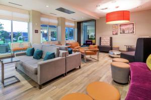 - une salle d'attente avec des canapés, des tables et des fenêtres dans l'établissement Hilton Garden Inn Arvada/Denver, CO, à Arvada