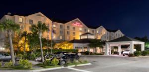 un hotel con coches estacionados en un estacionamiento por la noche en Hilton Garden Inn Charleston Airport, en Charleston