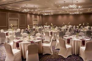 uma sala de banquetes com mesas, cadeiras e lustres em Hilton Wilmington/Christiana em Newark