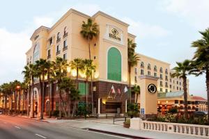 um edifício com palmeiras em frente a uma rua em Hilton Los Angeles/San Gabriel em San Gabriel