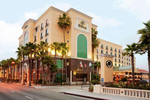 a building with palm trees in front of a street at Hilton Los Angeles/San Gabriel in San Gabriel