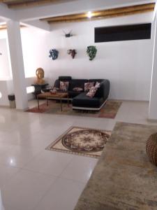 sala de estar con sofá negro y alfombra en Relic's mini Resort, en Puerto Cayo
