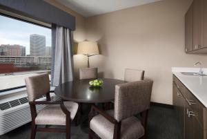 a room with a table and chairs and a kitchen at Holiday Inn Express & Suites Oklahoma City Downtown - Bricktown, an IHG Hotel in Oklahoma City