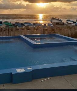 a large blue swimming pool next to the ocean at Relic's mini Resort in Puerto Cayo