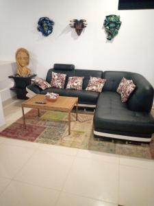 a living room with a black couch and a table at Relic's mini Resort in Puerto Cayo