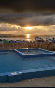 a large swimming pool with the ocean in the background at Relic's mini Resort in Puerto Cayo