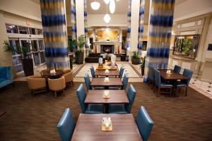 a restaurant with tables and chairs and a fireplace at Hilton Garden Inn Gettysburg in Gettysburg