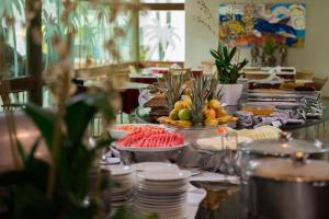 a buffet with plates and fruit on a table at Marulhos Resort - Flat e Studio in Porto De Galinhas