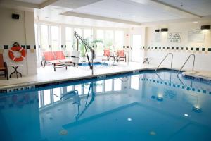 a large swimming pool with orange chairs and tables at Hilton Garden Inn Gettysburg in Gettysburg