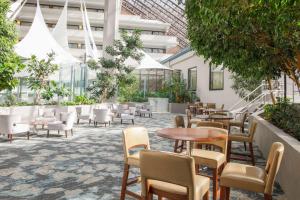a patio with tables and chairs in a building at DoubleTree by Hilton Rochester in Henrietta
