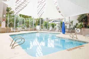 - une piscine dans un hôtel avec des tables et des chaises dans l'établissement DoubleTree by Hilton Rochester, à Henrietta