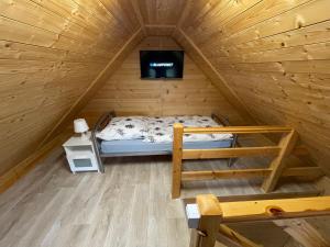 a small room with a bed in a wooden cabin at Lilly 5 Stars in Grzybowo