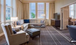 a living room with a couch and a tv at Hilton Richmond Downtown in Richmond