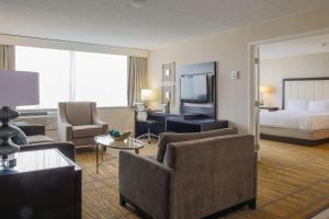 a hotel room with a bed and a living room at DoubleTree by Hilton Rochester in Henrietta