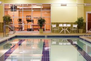 Hilton Scranton & Conference Center في سكرانتون: مسبح بجانبه طاولة وكراسي