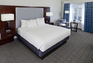 a hotel room with a large bed and a chair at Hilton Scranton & Conference Center in Scranton