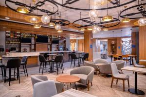 um restaurante com cadeiras e mesas e um bar em Hilton Garden Inn Sudbury, Ontario, Canada em Sudbury
